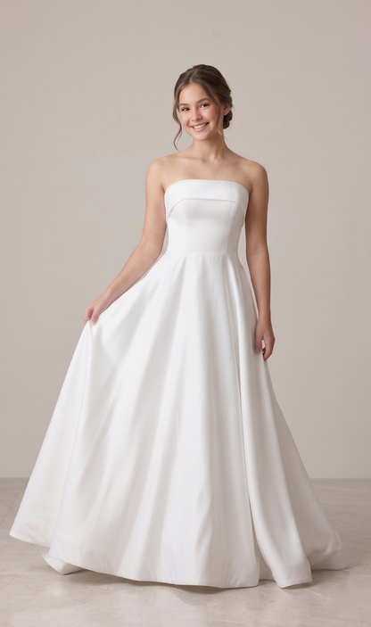 Woman wearing a strapless white wedding dress against a plain background