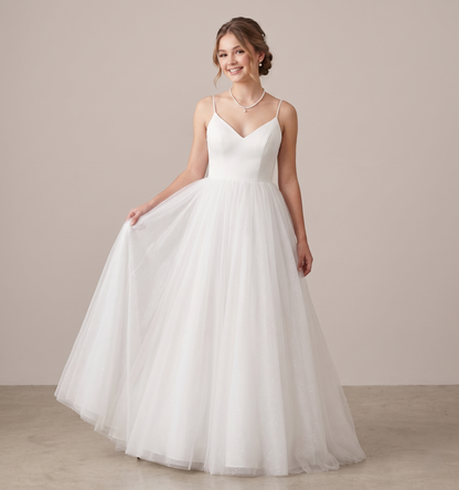 Woman wearing a white wedding dress against a plain background