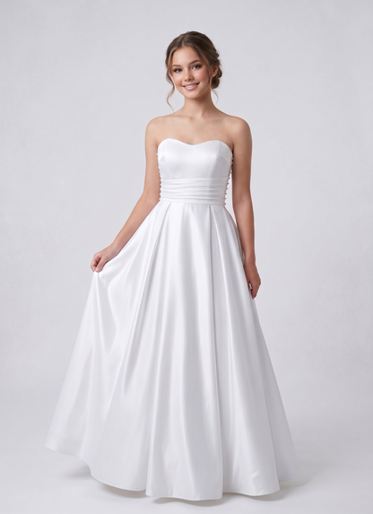 Woman wearing a strapless white wedding dress on a plain background