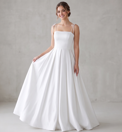 Woman wearing a white wedding dress against a plain background