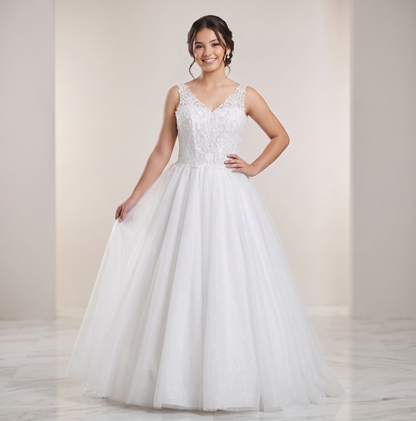 Woman wearing a white wedding dress with lace bodice and flowing skirt against a plain background