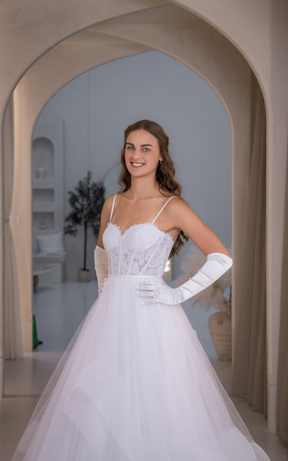Woman in a white wedding dress standing in an archway.