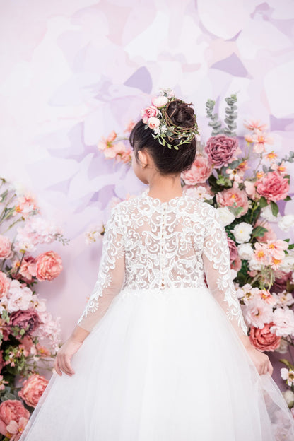 Woman in a white wedding dress standing among flowers with a decorative background