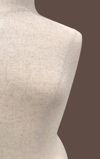 Mannequin torso with beige fabric on a brown background