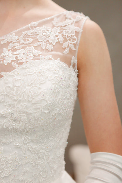 Close-up of a lace wedding dress with a neutral background