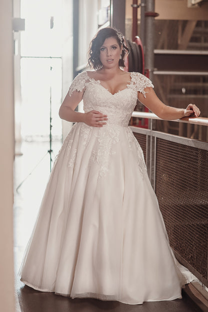 Woman wearing a white lace wedding dress indoors