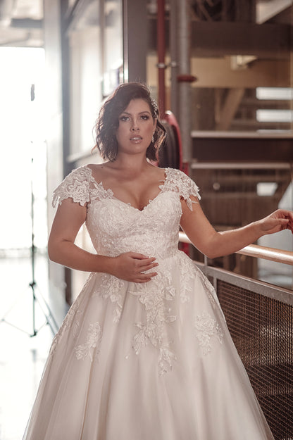 Woman wearing a white lace wedding dress in an indoor setting