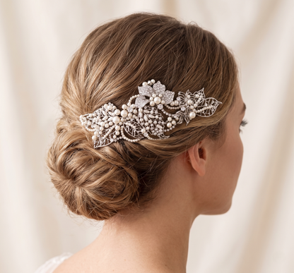 Woman with a decorative hairpiece in her hair against a neutral background