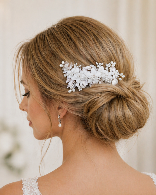 Woman with elegant hair styled with a decorative white hairpiece against a neutral background