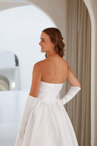 Woman in a white wedding dress with a plain background
