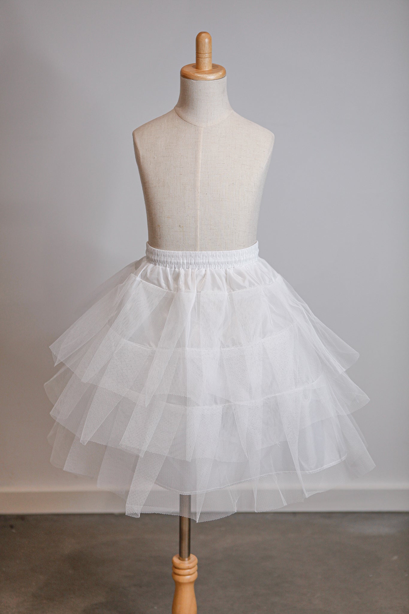 White tulle skirt on a mannequin against a plain background