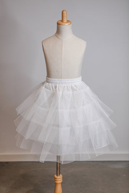 White tulle skirt on a mannequin against a plain background