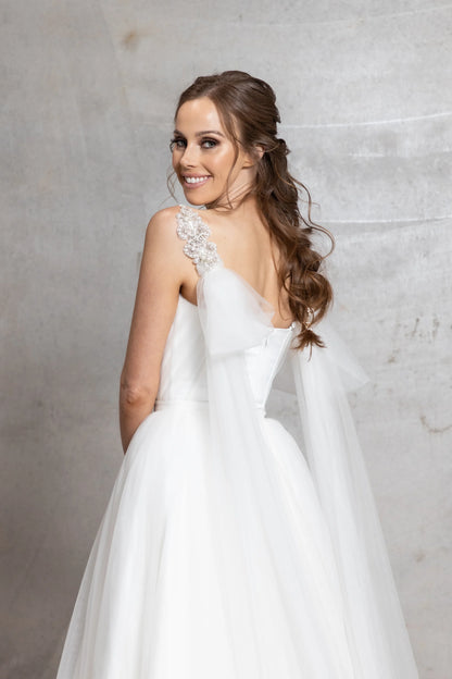 Woman in a white wedding dress with a gray background