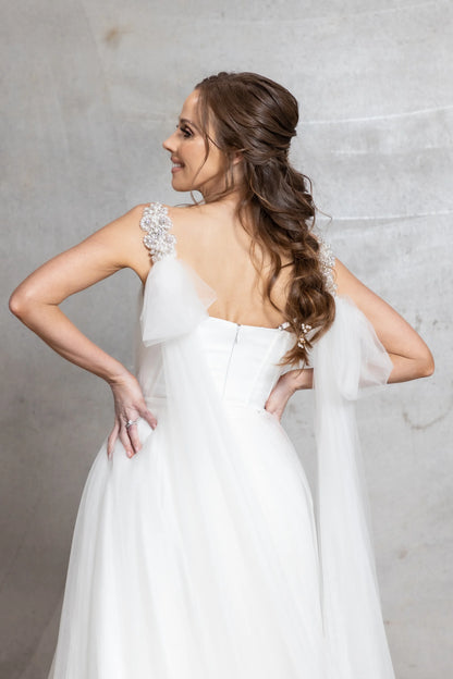 Woman in a white wedding dress with a gray background