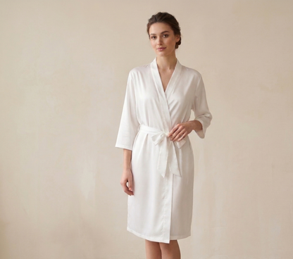 Woman wearing a white robe against a plain background