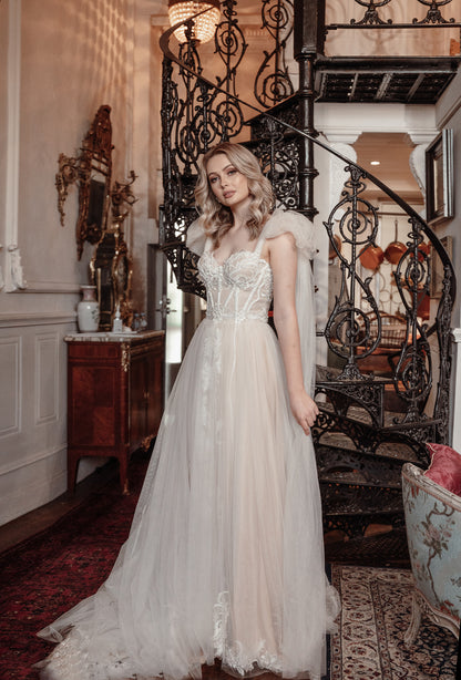 Woman in a white wedding dress standing in an elegant interior setting