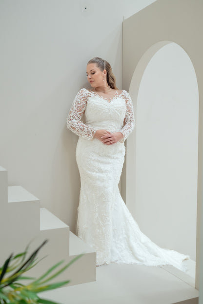 Woman wearing a white lace wedding dress in a minimalistic setting
