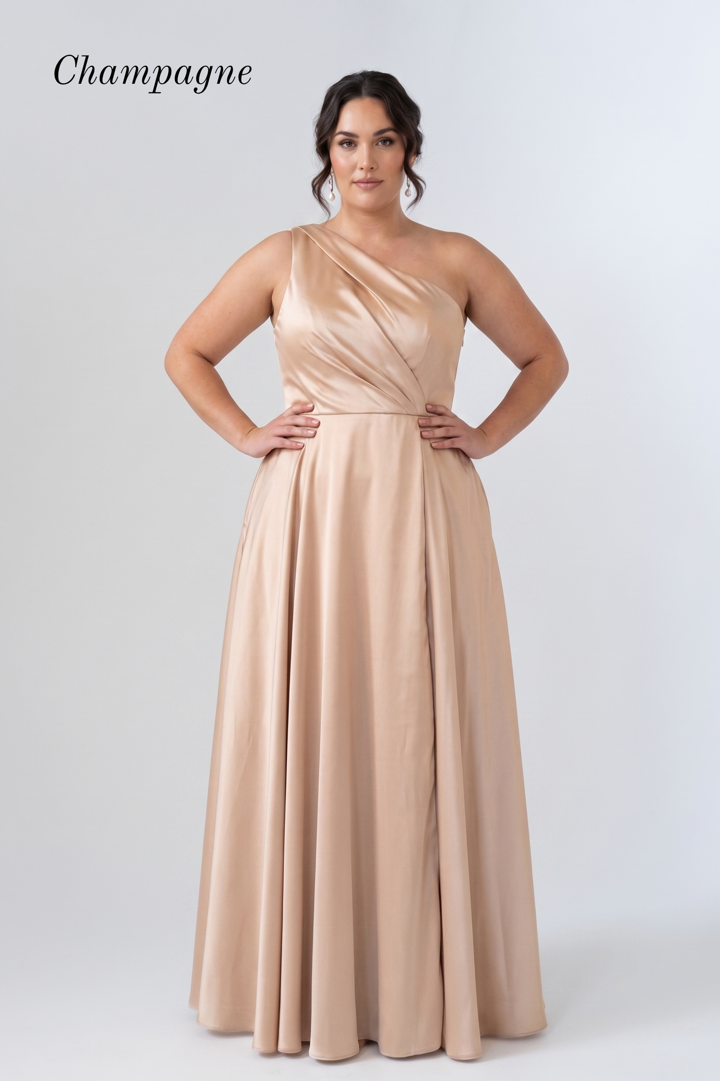 A woman modeling a floor-length champagne one-shoulder gown against a light gray studio background. The word 'Champagne' appears in the upper left corner.