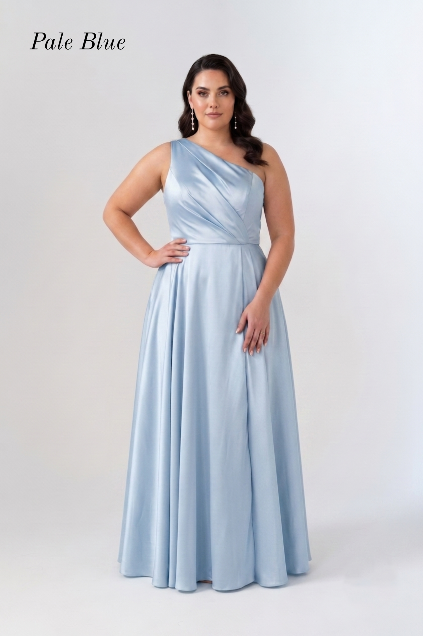 A woman modeling a floor-length pale blue satin gown with a one-shoulder neckline and a flared skirt, standing against a light gray studio background. The words 'Pale Blue' appear in the upper left corner.