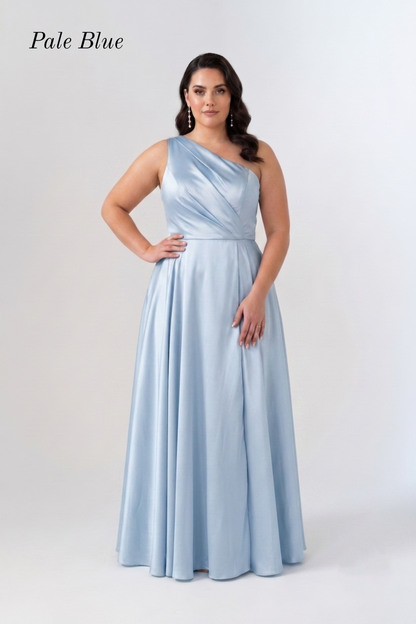A woman modeling a floor-length pale blue satin gown with a one-shoulder neckline and a flared skirt, standing against a light gray studio background. The words 'Pale Blue' appear in the upper left corner.