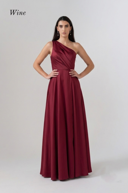 A woman modeling a floor-length one-shoulder formal dress in a deep wine red color, standing against a light gray studio background. The word 'Wine' appears in the upper left corner.