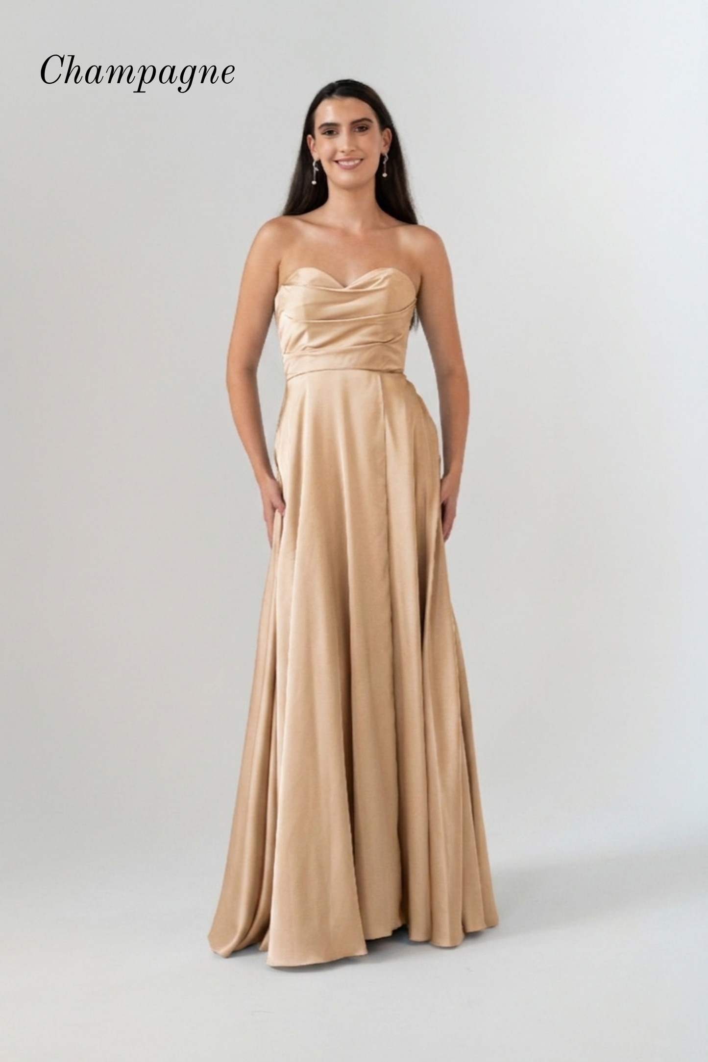 A woman modeling a strapless champagne A-line formal gown against a light gray studio background. The word 'Champagne' is printed in the upper left corner.