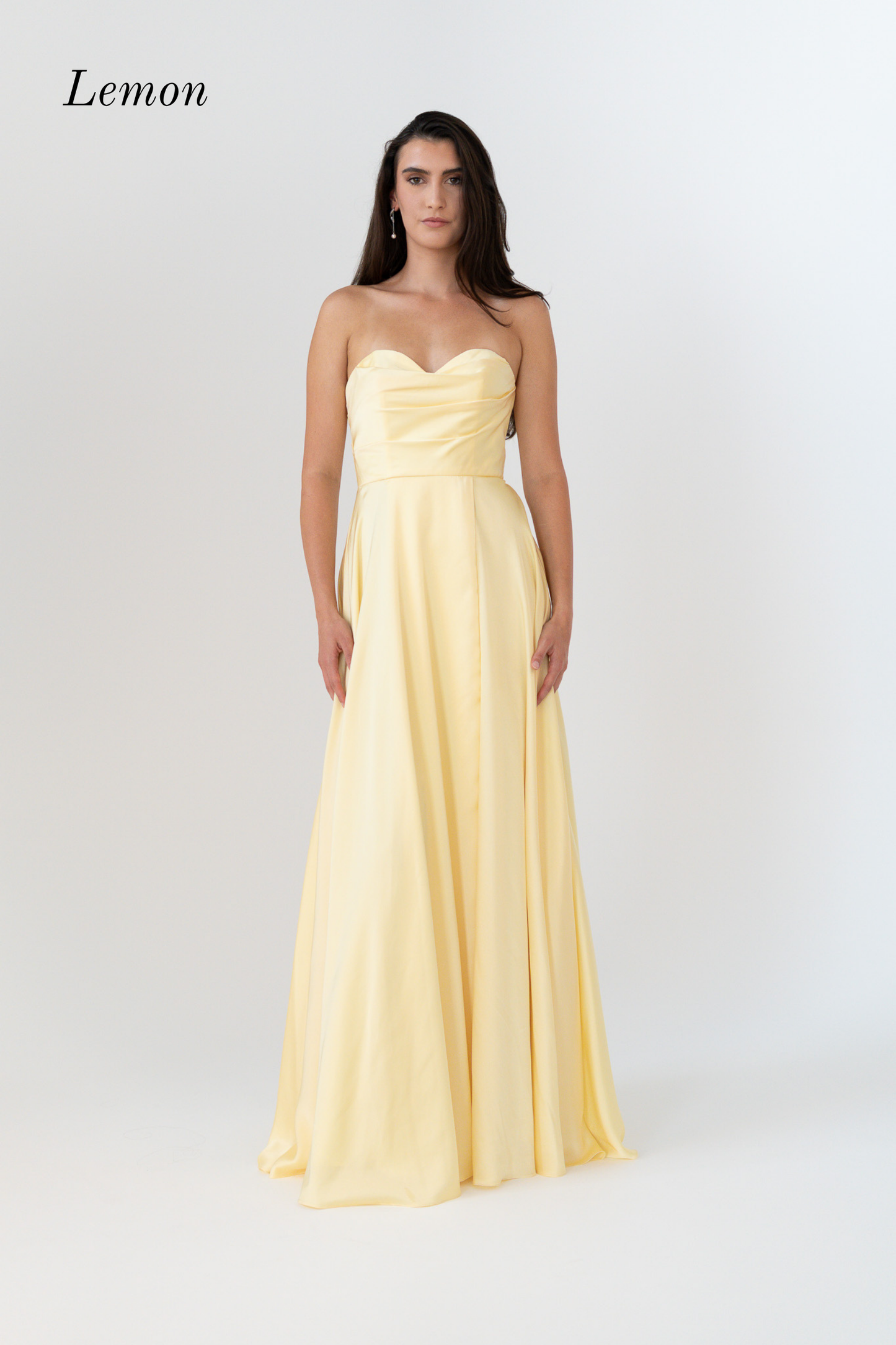 A woman modeling a lemon yellow strapless floor-length gown against a plain light gray studio background. The word 'Lemon' appears in the upper left corner.