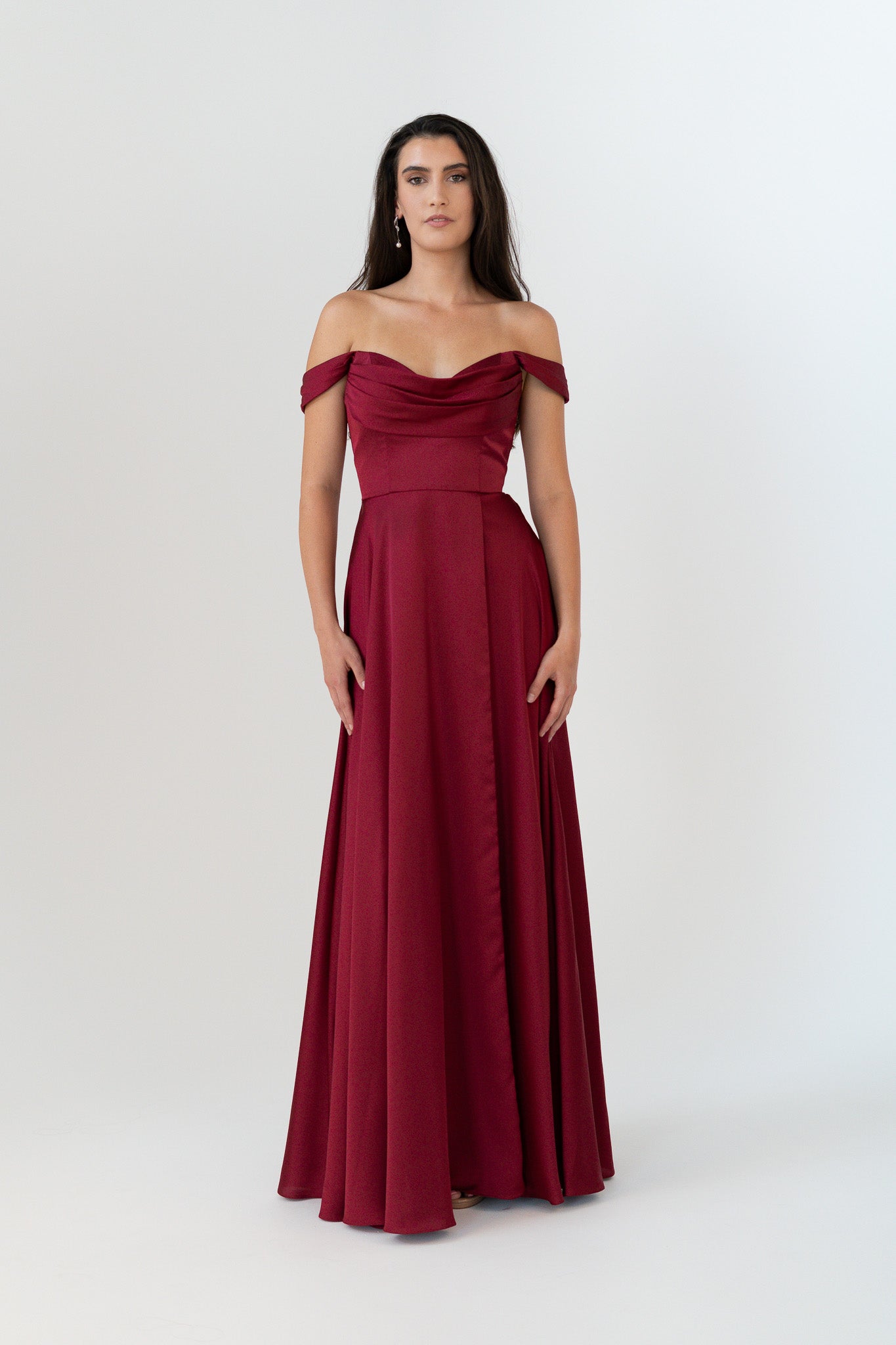 Woman wearing a burgundy off-shoulder gown on a white background