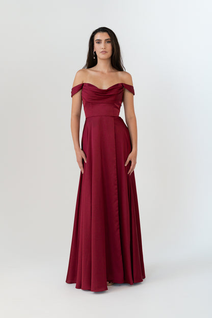 Woman wearing a burgundy off-shoulder gown on a white background