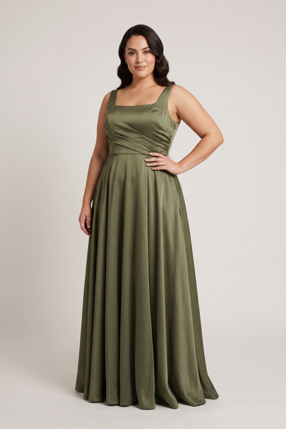 A woman modeling a floor-length olive green sleeveless gown with a square neckline and a flowing skirt, photographed against a plain light gray studio background.