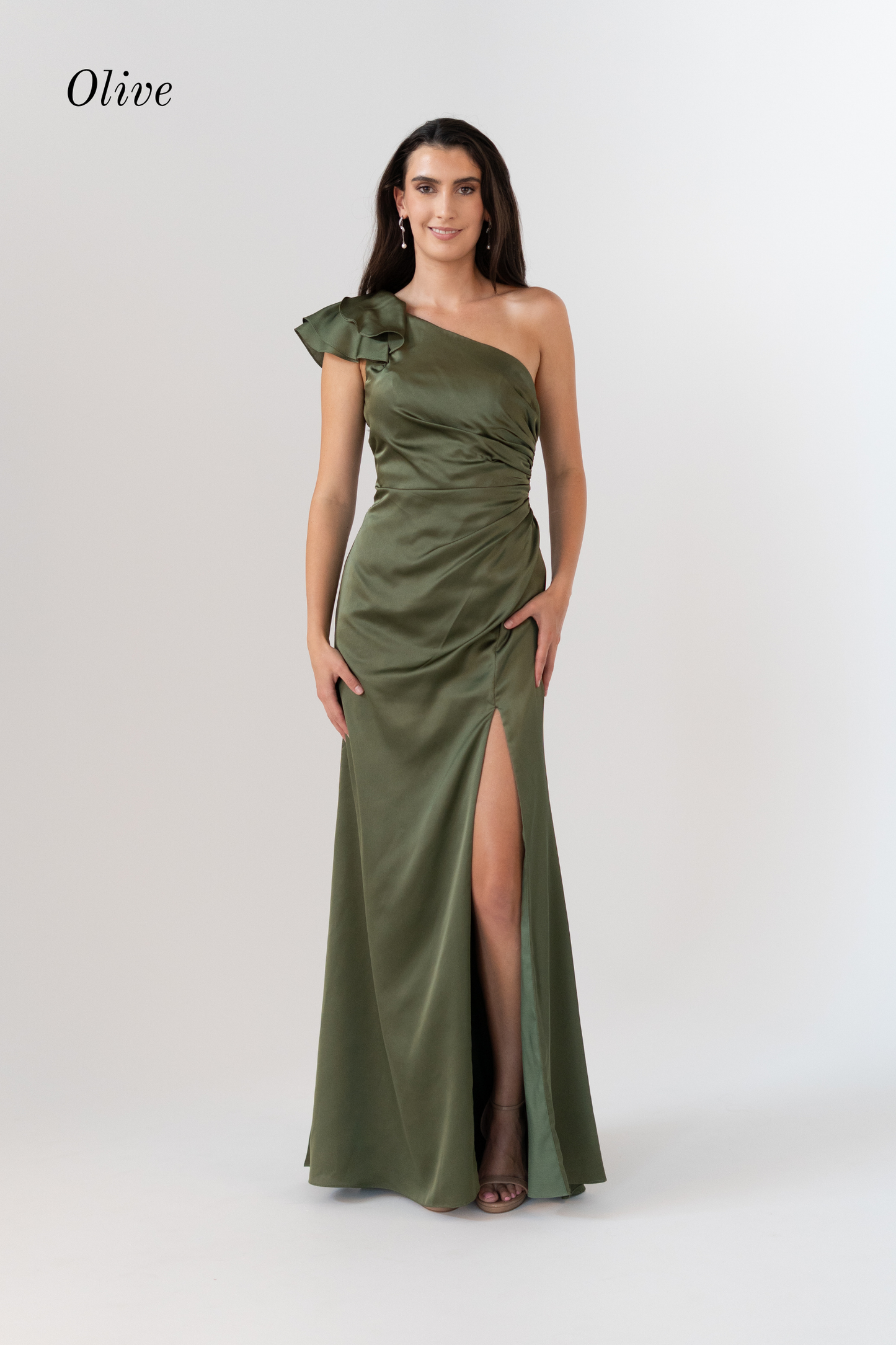 A woman modeling an olive green one-shoulder floor-length gown with a high thigh slit, photographed against a light gray studio background. The word 'Olive' appears in the upper left corner.