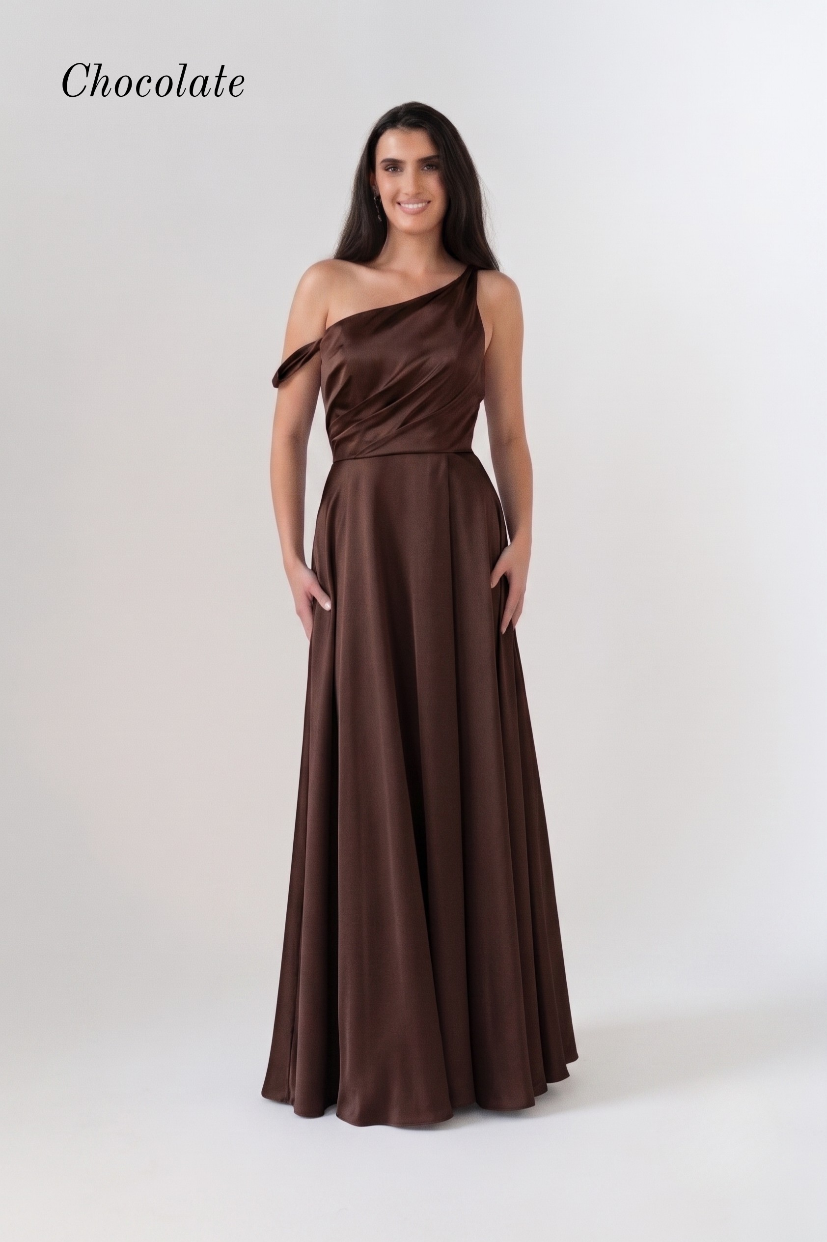 A woman modeling a chocolate brown one-shoulder floor-length gown against a plain light gray studio background. The word 'Chocolate' appears in the upper left corner.