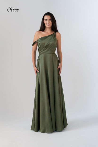 A woman modeling an olive green one-shoulder floor-length gown against a light gray studio background. The word 'Olive' appears in the upper left corner.