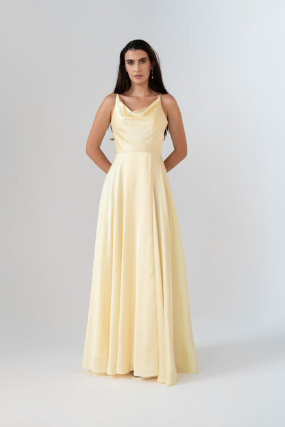 Woman wearing a light yellow evening gown against a white background