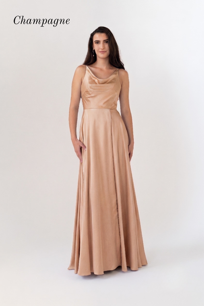 A woman modeling a floor-length champagne gown with a draped neckline and sleeveless design, standing against a plain light background. The word 'Champagne' appears in the upper left corner.