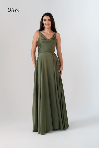 A woman modeling a sleeveless olive green maxi dress with a draped neckline and a flowing skirt, standing against a light gray studio background. The word 'Olive' appears in the upper left corner.