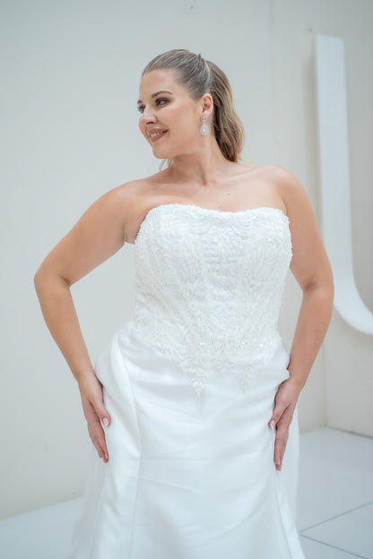 Woman wearing a white strapless wedding dress in a minimalistic setting