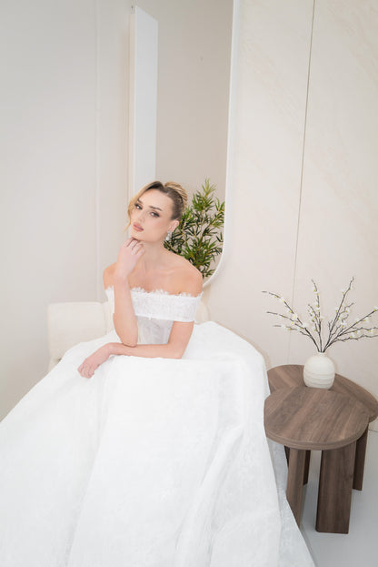 Woman in a white strapless dress sitting on a chair in a minimalistic room