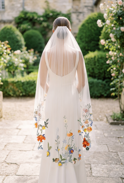Bride wearing a floral embroidered veil in an outdoor garden setting