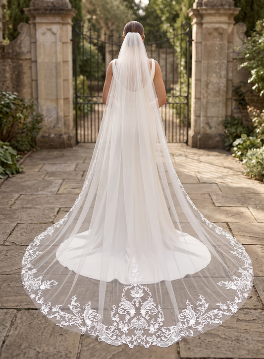 Bride wearing a long, elegant wedding veil in an outdoor setting.