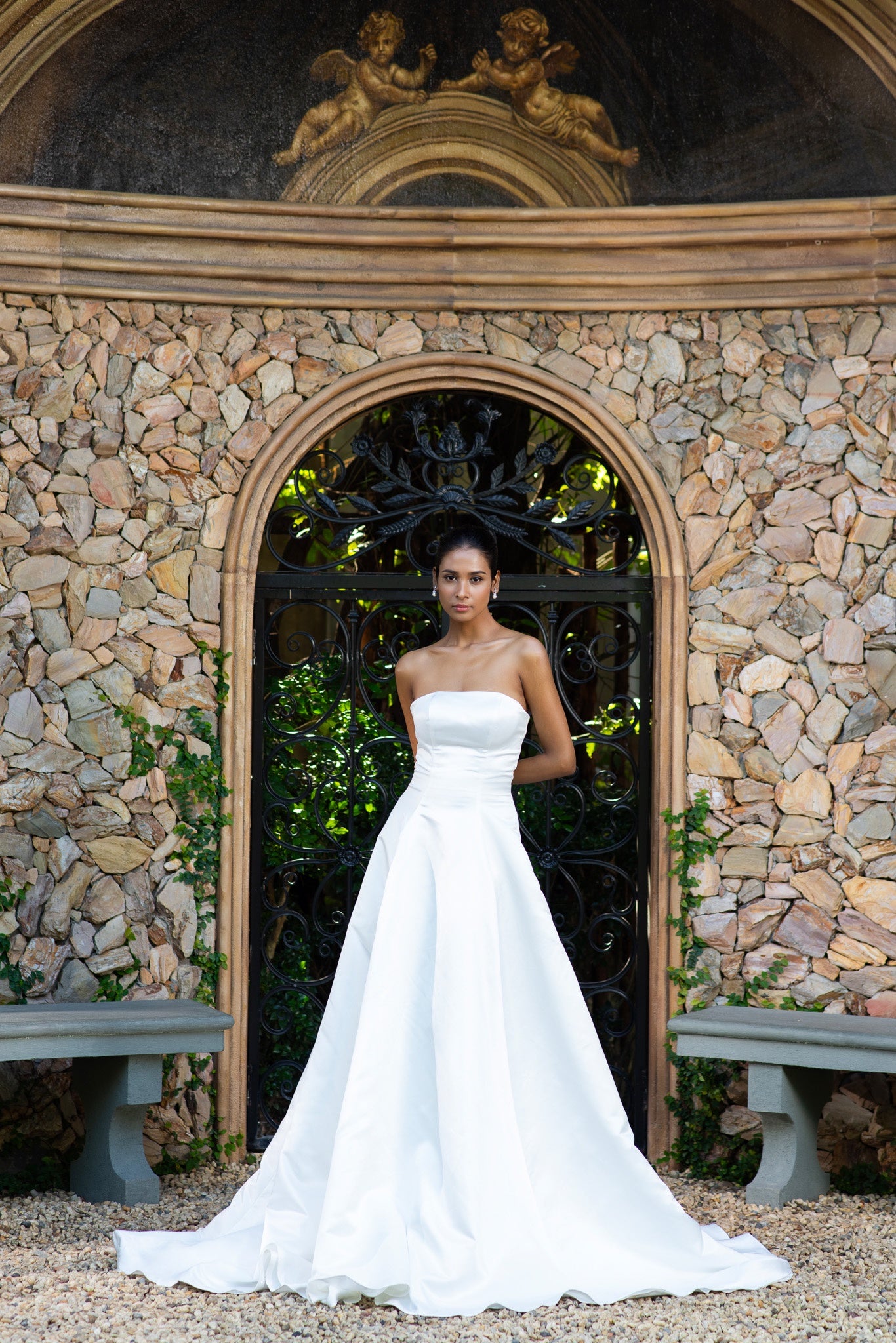 Bride in satin A-line wedding dress at garden entrance