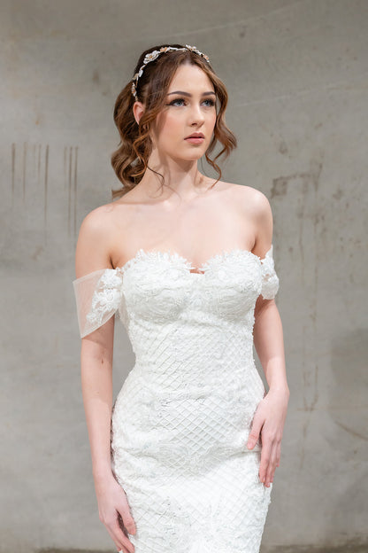 Woman wearing a white strapless dress against a plain background