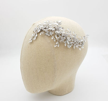 Silver hairpiece on a mannequin head against a white background