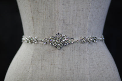 Silver belt with decorative elements on a mannequin against a black background