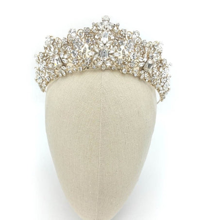 Gold tiara with crystals on a mannequin head against a white background