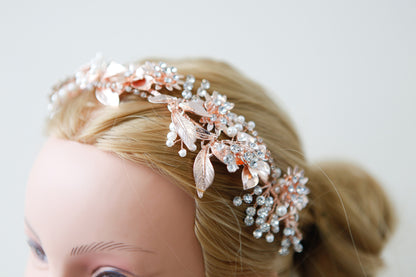 Decorative headband with pearls and leaves on a mannequin head against a light background