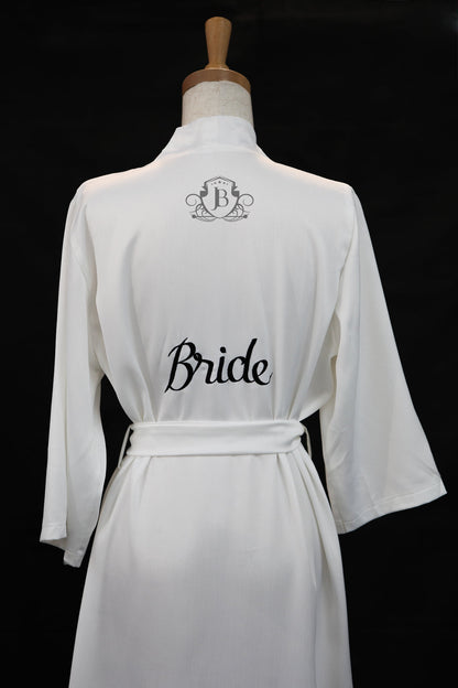 White robe with 'Bride' text on a mannequin against a black background