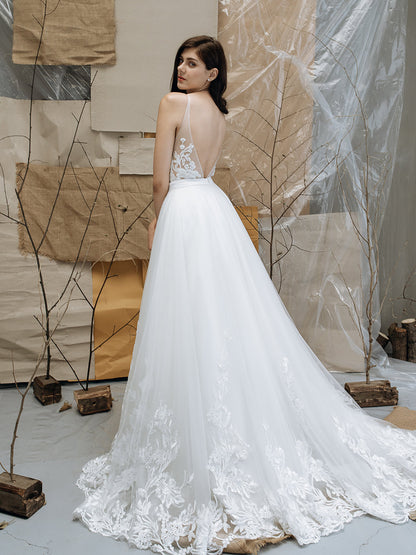 Woman wearing a white wedding dress with lace details in a minimalistic setting